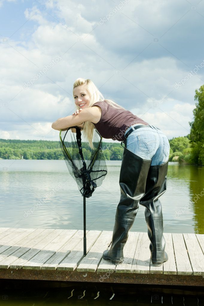 Fishing woman with landing net standing on pier Stock Photo by ©phb.cz  4589443