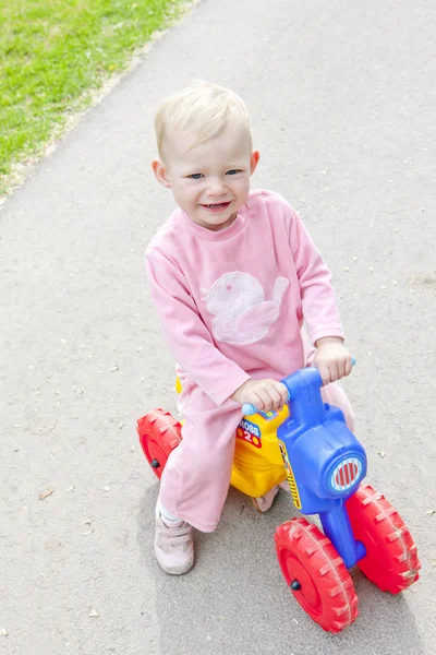 Маленька дівчинка на іграшковому мотоциклі — стокове фото