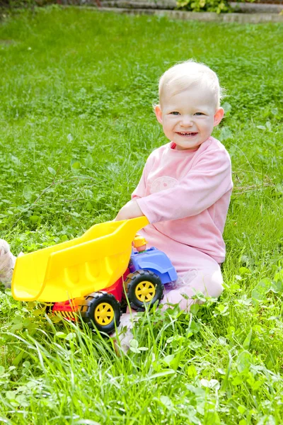 Маленькая девочка играет с маленькой машиной — стоковое фото
