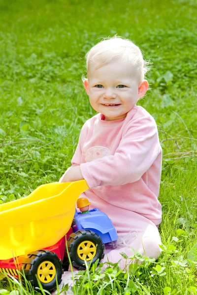 Маленькая девочка играет с маленькой машиной — стоковое фото