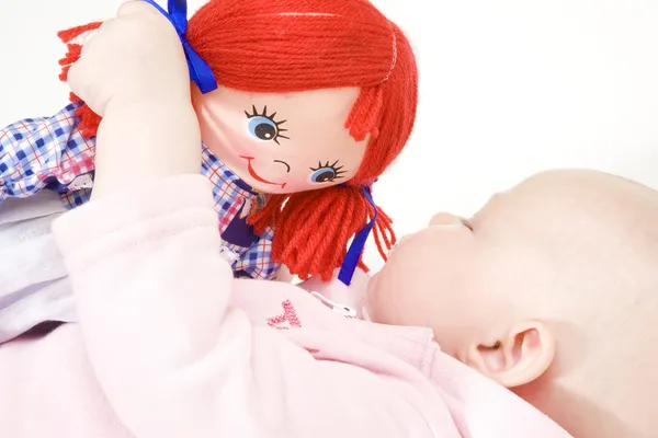W pozycji leżącej dziecko dziewczynka z lalką — Zdjęcie stockowe