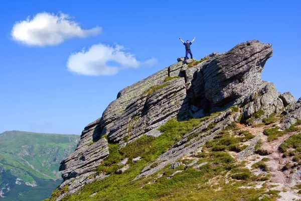 Hombre permanecer en la cima de la montaña — Foto de Stock