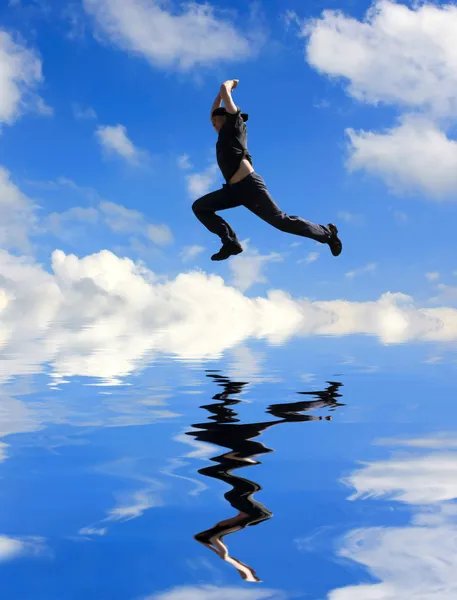 Человек прыгает над водой — стоковое фото