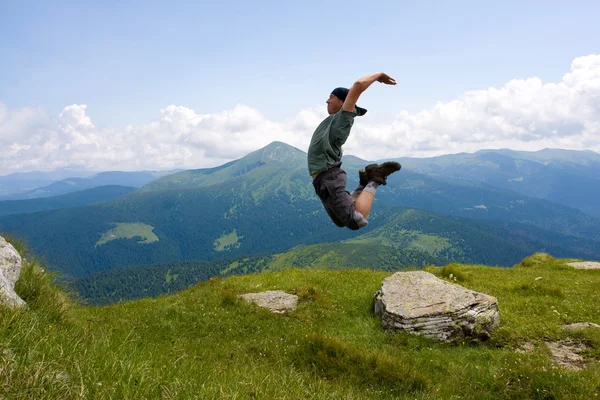 Saltare l'uomo in montagna Foto Stock Royalty Free