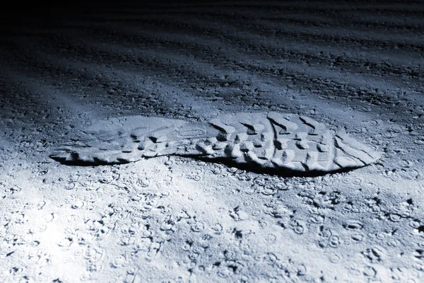 Upplysta fotsteg på sand på natten — Stockfoto