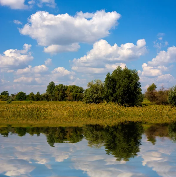 Krajina s pěkné mraky nad jezerem — Stock fotografie