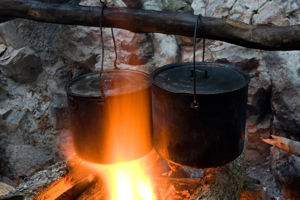 Two tourists kettles on campfire — Stock Photo, Image