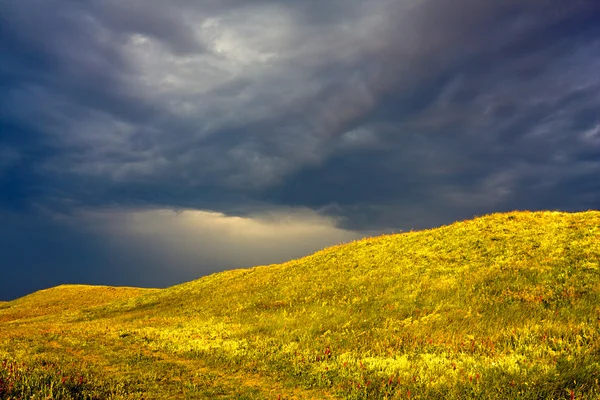 Colina amarela sob nuvens escuras — Fotografia de Stock