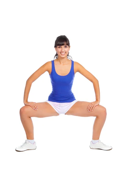 Beautiful fitness trainer squats — Stock Photo, Image