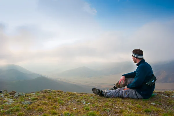 Hiker sits on a peak — Stock Photo, Image