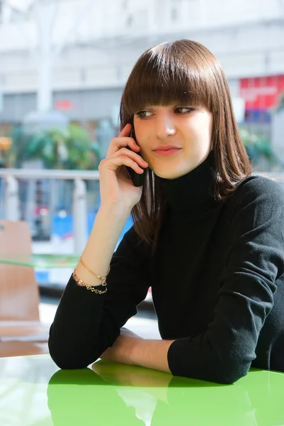 Ung flicka talar på en mobil — Stockfoto