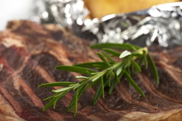 Detail listů rozmarýnu na t-bone-steak — Stock fotografie