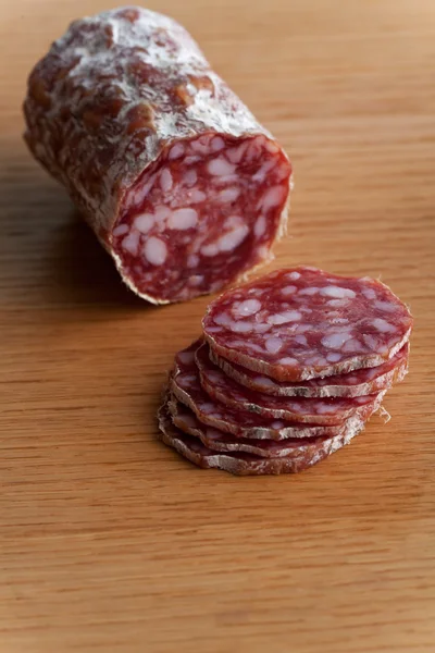 Slices of an a italian salami on an oak table