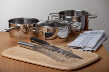 Egg beater and pots on a wooden table