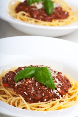 Teller mit spagetti Bolognese und Basilikumblatt