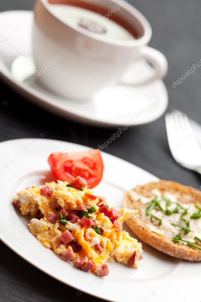 Scrambled eggs and ham cubes on a white plate