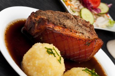 Bavarian roast pork dish with potato dumplings clipart