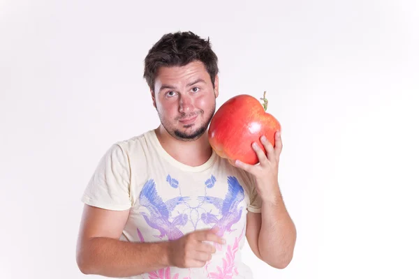 Stock image Young man bites a huge tasty apple, on white