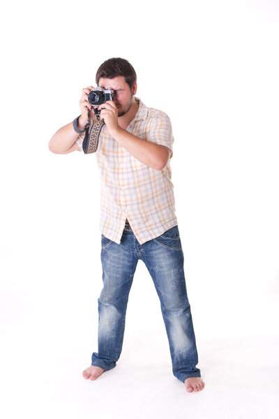 Young man with old-fashion 35mm camera posing against white background