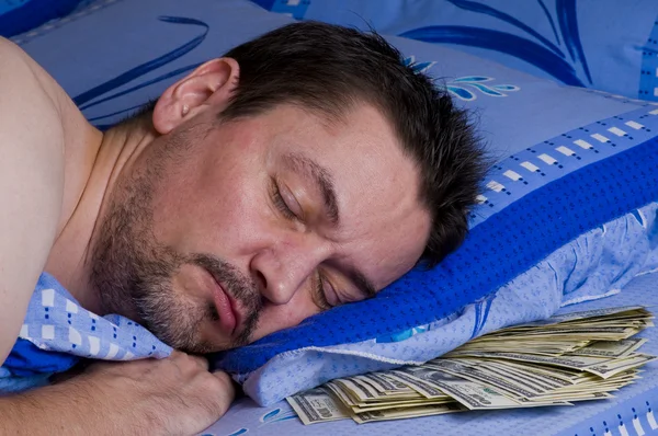 Hombre con dinero bajo su almohada —  Fotos de Stock