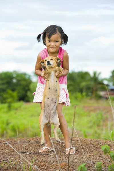 Farmer girl holding a dog — Stock Photo, Image