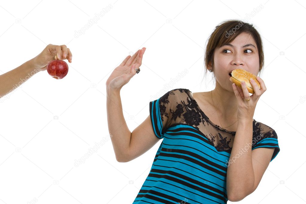 Woman with hamburger refusing an apple