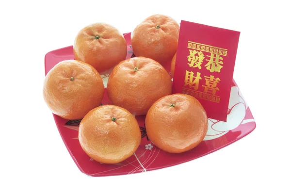 Mandarinen und rotes Päckchen auf Teller — Stockfoto