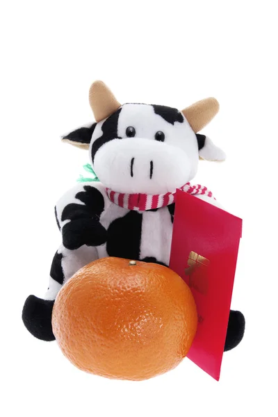 Мягкая игрушка корова и мандарин — стоковое фото