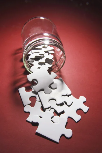 ガラスの瓶からこぼれることのジグソー パズルのピース — ストック写真