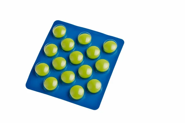 Zielone tabletki w niebieskim opakowaniu. — Zdjęcie stockowe