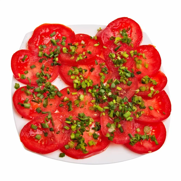 Skivade tomater med gräslök på tallrik. — Stockfoto