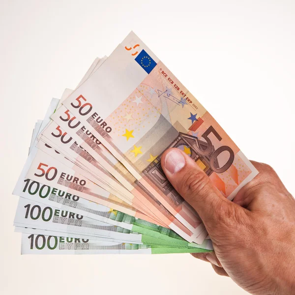 50 och 100 eurosedlar hålla rätt manlig hand. Royaltyfria Stockfoton