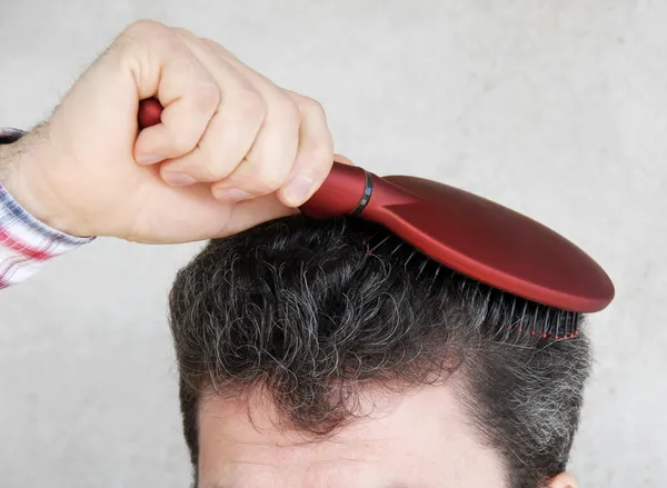 Człowiek szczotkowanie włosów — Zdjęcie stockowe