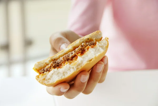 Hamburger in hand — Stockfoto