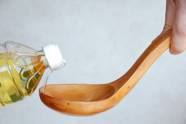 Verter aceite en una cuchara de madera — Foto de Stock