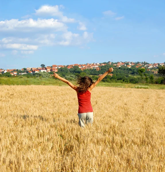 Happy girl jumping in wheat field — Stock Photo, Image