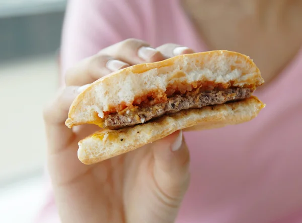 Hamburger in hand — Stockfoto