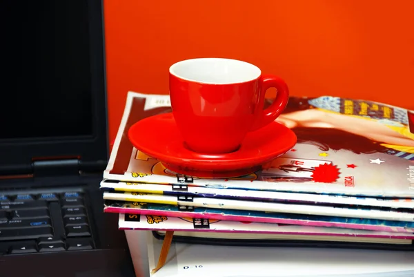 Červený pohár na časopisy a notebook — Stock fotografie