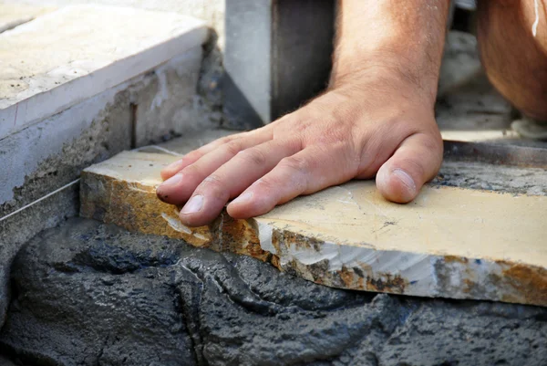 Arbeiter Hand auf Steinplatte — Stockfoto