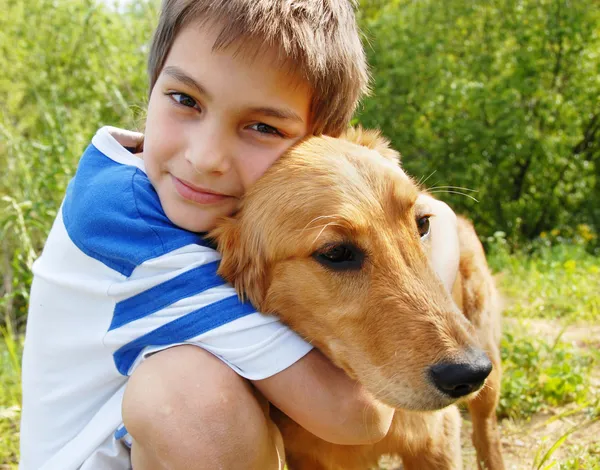 Jongen knuffelen zijn hond Stockfoto