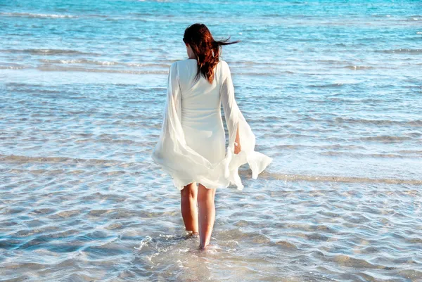 Женщина в белом платье на берегу моря — стоковое фото