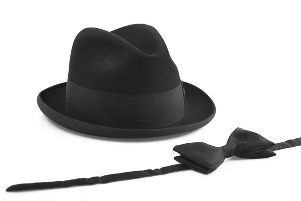 Черная винтажная шляпа и бабочка на белом фоне — стоковое фото