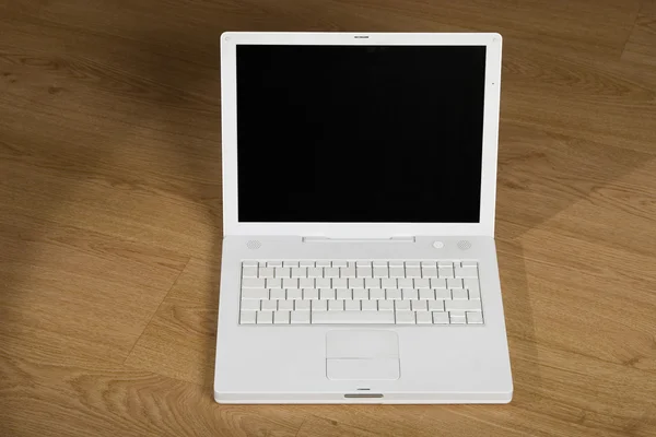 Bílý notebook na dřevěné pozadí — Stock fotografie