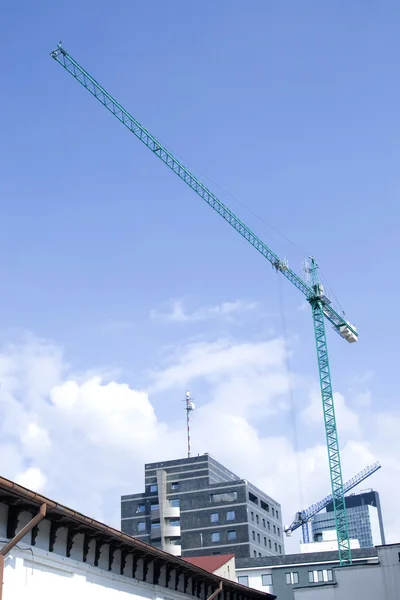 Věžový jeřáb pracuje na konstrukci na modré obloze — Stock fotografie