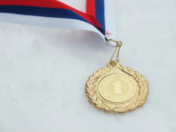 Золотая медаль и снег — стоковое фото