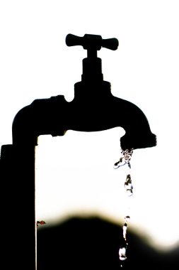 Silhouette of a tap dripping water clipart