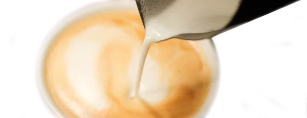 Melk van een kruik gieten in een kopje koffie — Stockfoto