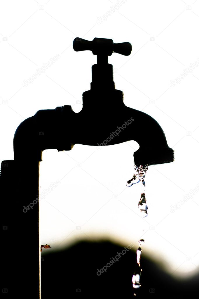Silhouette of a tap dripping water