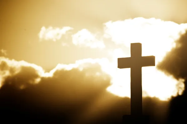 Silhouette d'une croix dans des faisceaux de lumière — Photo