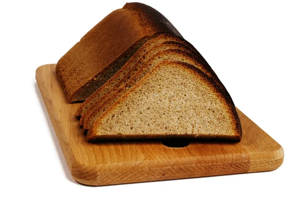 Pan de centeno en una tabla de pan — Foto de Stock